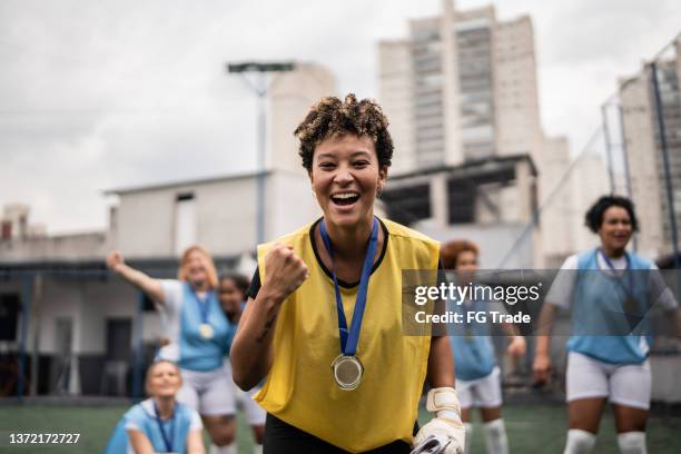 portrait of a female soccer player celebrating winning a medal - woman goalie stock pictures, royalty-free photos & images