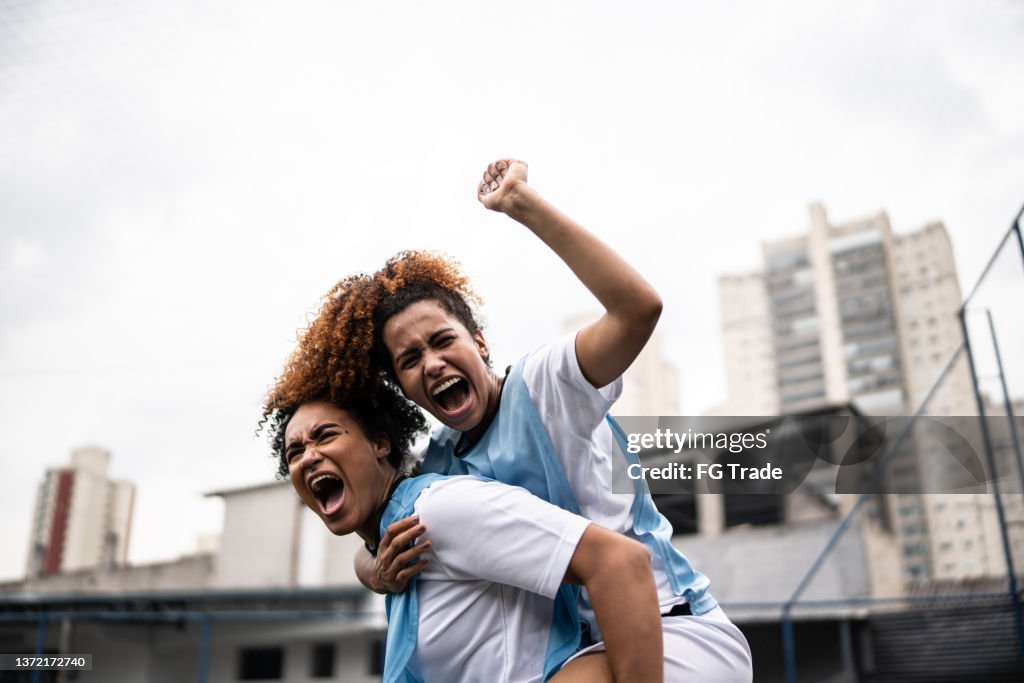 Female soccer players celebrating a goal