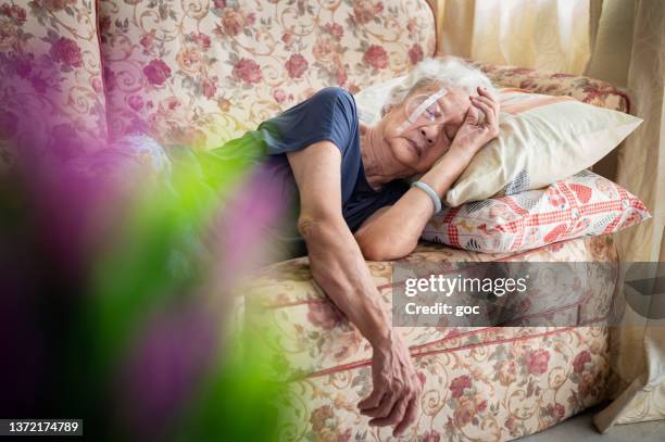 senior asian woman take a rest and covering her eye with protective shield after eye cataract surgery - cataract surgery stock pictures, royalty-free photos & images