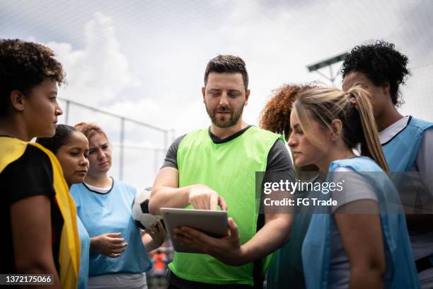 coach and female soccer players planning a game - sports team work stock pictures, royalty-free photos & images