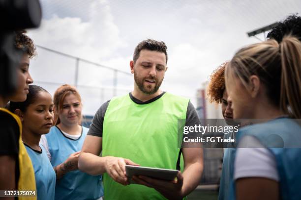 treinador e jogadoras de futebol planejando um jogo - equipamento de equipa - fotografias e filmes do acervo