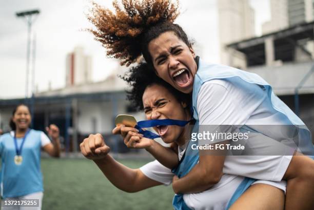 female soccer players celebrating winning a medal - medallist imagens e fotografias de stock