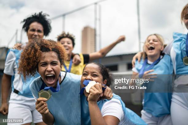 female soccer players celebrating winning a medal - medalist stock pictures, royalty-free photos & images