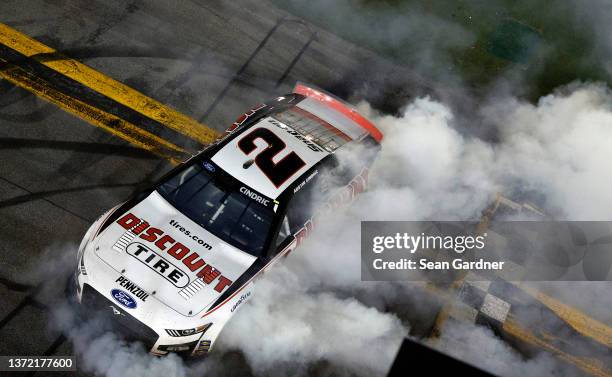 Austin Cindric, driver of the Discount Tire Ford, celebrates with a burnout after winning the NASCAR Cup Series 64th Annual Daytona 500 at Daytona...
