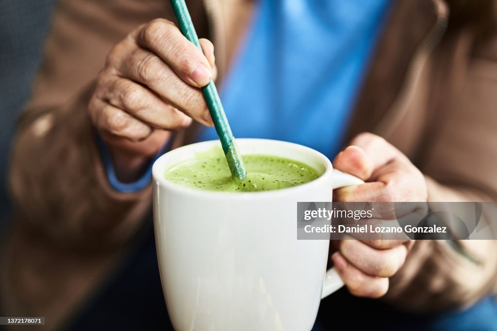 Unrecognizable woman with matcha tea cup