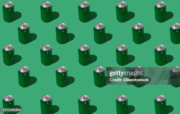 pattern of green beer or soda cans with hard shadow on green background. soda, beer, drink, alcohol, bar, brewery, industry and factory concept. - hard liquor stock pictures, royalty-free photos & images