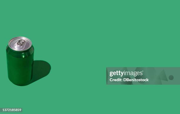 green beer or soda cans with hard shadow on green background. soda, beer, drink, alcohol, bar, brewery, industry and factory concept. - hard liquor stock pictures, royalty-free photos & images