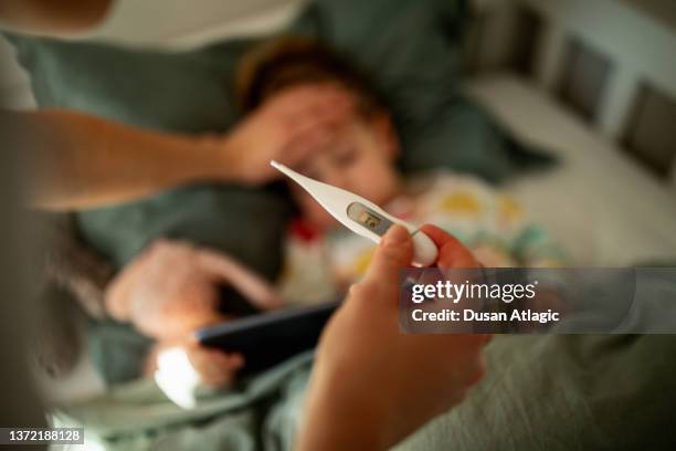 mother taking care of sick child - febre imagens e fotografias de stock