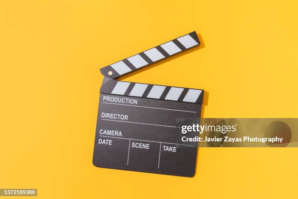 clapper board on yellow background - claqueta de cine fotografías e imágenes de stock