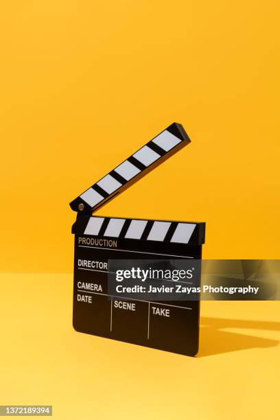 clapper board on yellow background - claqueta de cine fotografías e imágenes de stock