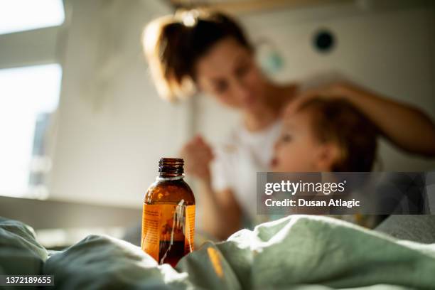 mother taking care of sick child - syrup stock pictures, royalty-free photos & images