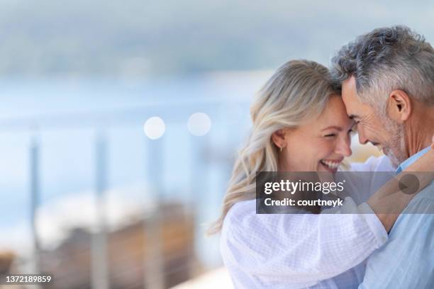 reifes paar tanzt in einem haus am wasser oder einer ferienvilla. - happy couple tanzen stock-fotos und bilder