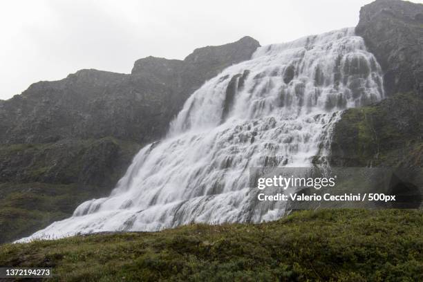 scenic view of waterfall against sky - islanda fotografías e imágenes de stock