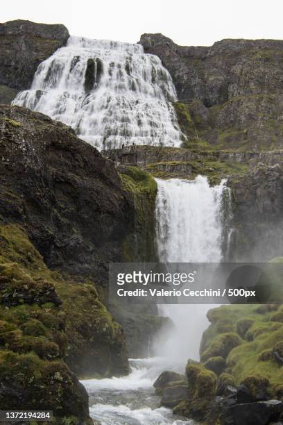 scenic view of waterfall against sky - islanda fotografías e imágenes de stock