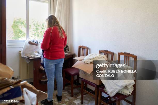 caucasian woman putting clothes from wardrobe into donation box for charity - belongings stock-fotos und bilder