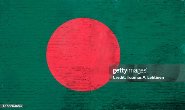 full frame photo of a weathered flag of bangladesh painted on a plastered brick wall. - bangladesh national flag stock-fotos und bilder