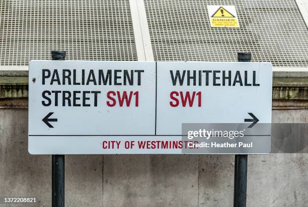 street signs directing pedestrians and drivers to parliament street and whitehall in london, england - whitehall london stock-fotos und bilder