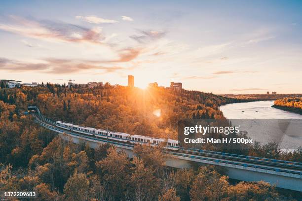 fall season sunset - edmonton,high angle view of bridge over river against sky during sunset,edmonton,alberta,canada - järnvägstransport transport bildbanksfoton och bilder