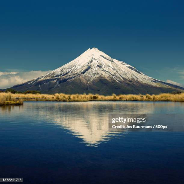 mount taranaki reflection,scenic view of lake by snowcapped mountain against clear blue sky,taranaki,new zealand - new zealand volcano 個照片及圖片檔