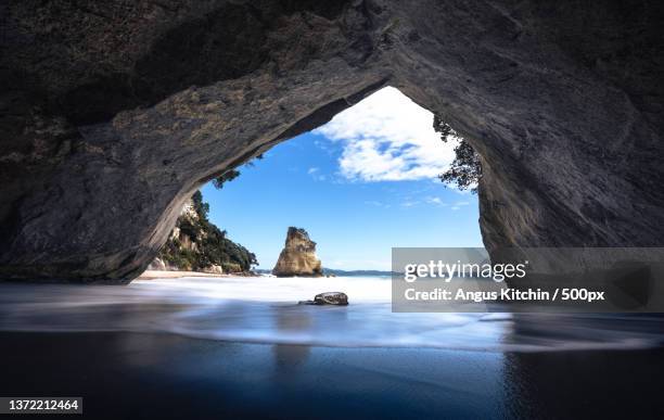 cathedral cove,scenic view of sea seen through cave - beach stone stock-fotos und bilder