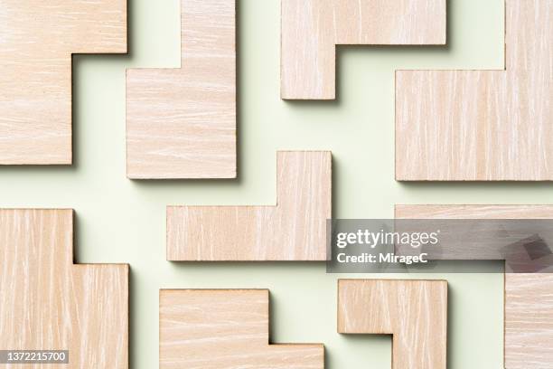 neatly arranged wooden puzzle jigsaw pieces - teaser stock-fotos und bilder