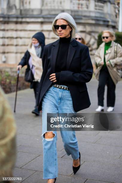 Sarah Harris seen wearing ripped denim jeans, Chanel belt, navy blazer outside Roksanda during London Fashion Week February 2022 on February 21, 2022...