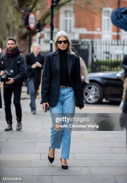 Sarah Harris seen wearing denim jeans, Chanel belt, black blazer, turtleneck outside Erdem during London Fashion Week February 2022 on February 21,...