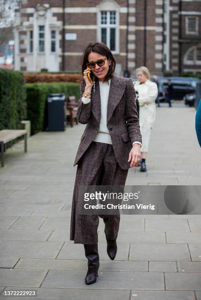 Guest is seen wearing brown checkered waisted blazer, cropped pants, black knee high boots outside Roksanda during London Fashion Week February 2022...