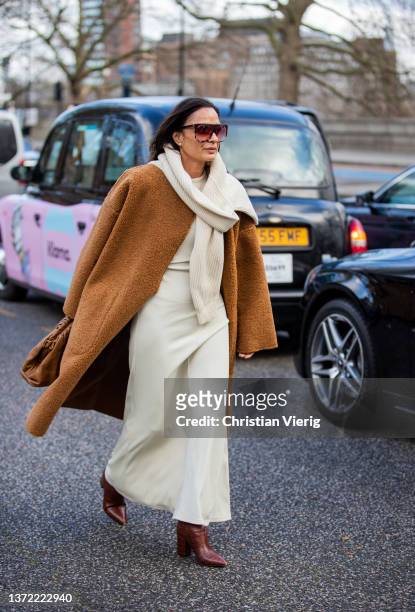 Guest is seen wearing brown teddy coat, creme white dress outside Roksanda during London Fashion Week February 2022 on February 21, 2022 in London,...