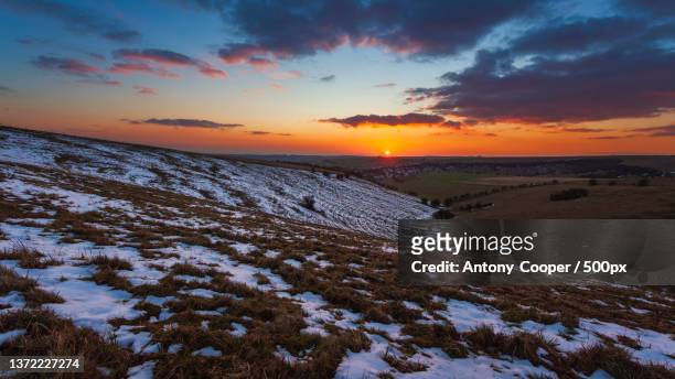 south downs,scenic view of snow covered land against sky during sunset,east sussex,united kingdom,uk - sussex stock pictures, royalty-free photos & images