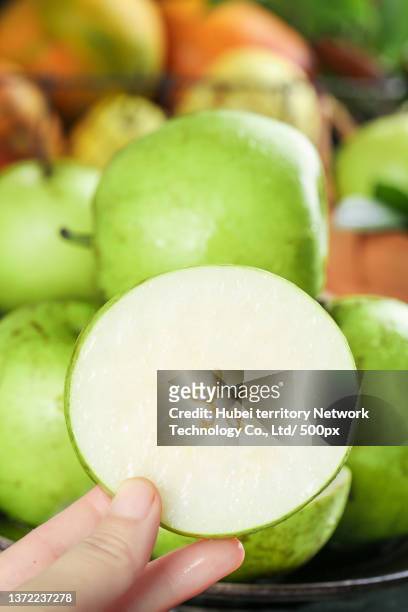 hold the cut green crown pear on the shallow bottom - aziatische peer stockfoto's en -beelden