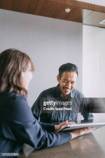 man meeting female banker for financial advice - business mann tablet finance stock-fotos und bilder