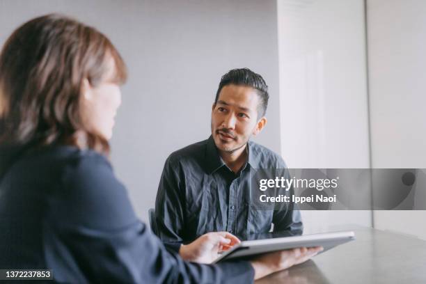 man meeting female banker for financial advice - escritura japonesa imagens e fotografias de stock