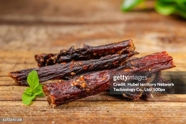 beef jerky on a wooden bottom - jerky stock pictures, royalty-free photos & images