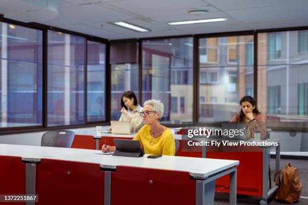 diverse group of female students attending university lecture - avondschool stockfoto's en -beelden