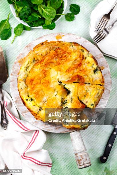 spinach feta cheese pie. greek pie spanakopita. spinach pie from filo pastry cut in slices. top view. - spinach pie stock pictures, royalty-free photos & images