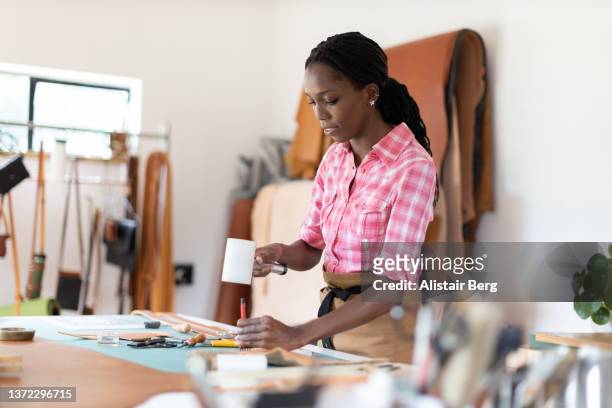 female small business owner working in her leatherwork studio - maroquinerie photos et images de collection