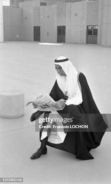 Dignitaire saoudien en vêtement traditionnel et keffieh lisant un journal écrit en arabe à Djeddah le 11 avril 1981.