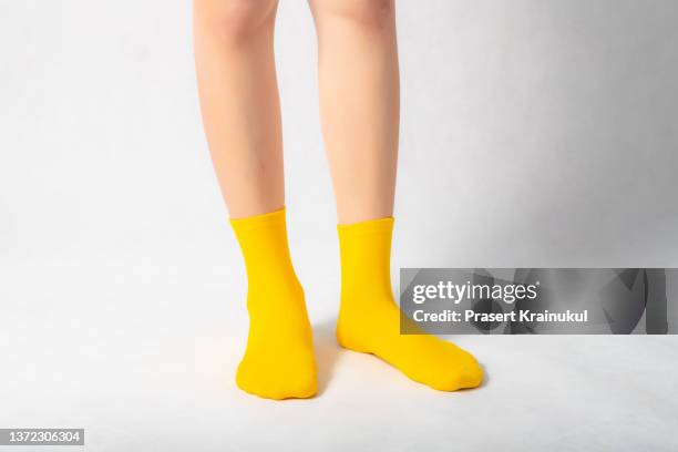 woman feets in yellow socks - socks fotografías e imágenes de stock