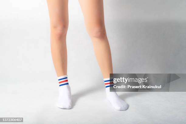 woman feets in warmwhite socks with blue and red stripes - white women feet fotografías e imágenes de stock