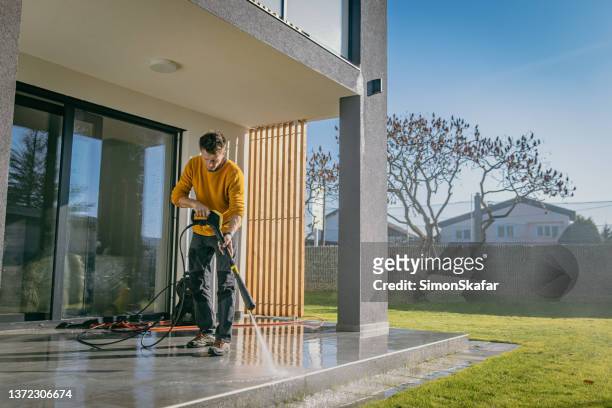 homem limpando as telhas do terraço do apartamento - high pressure cleaning - fotografias e filmes do acervo
