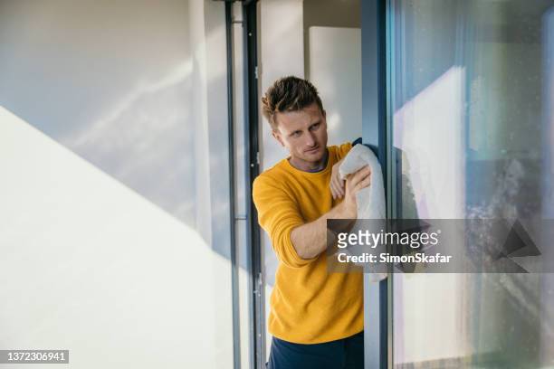 man using a rag to wipe the window frame - microfiber towel stock pictures, royalty-free photos & images