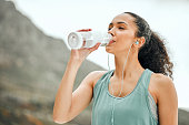 Shot of a young woman taking a break from working out to drink water