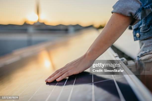 manos de mujer tocando paneles de energía solar en la central eléctrica - herramientas industriales fotografías e imágenes de stock