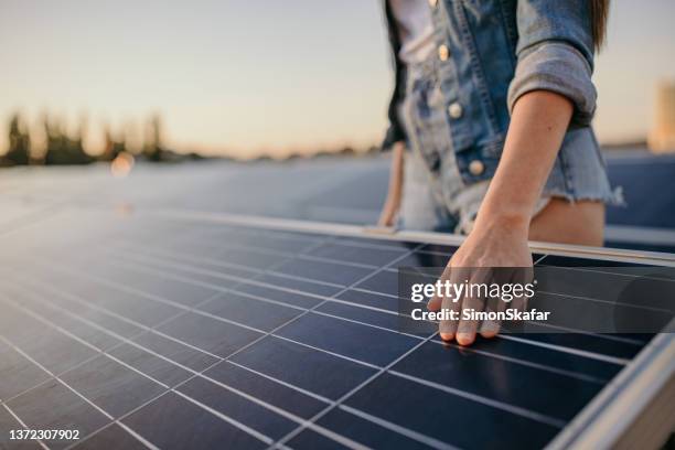 woman hands touching solar energy panels at power station - zonnecellen stockfoto's en -beelden