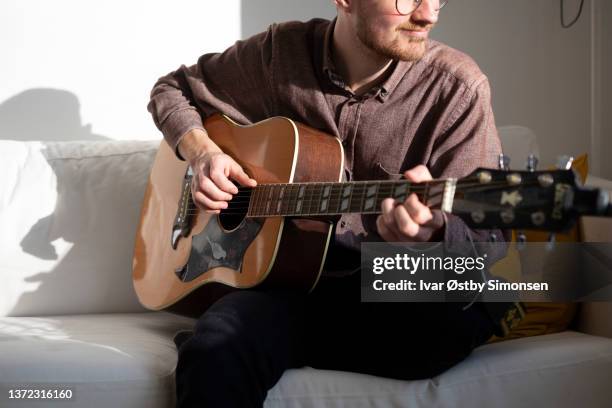 musiker, der die akustische gitarre spielt - akustikgitarre stock-fotos und bilder