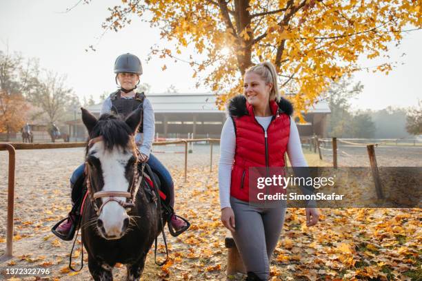 mother teaching her daughter horseback riding - equestrian individual dressage stock pictures, royalty-free photos & images