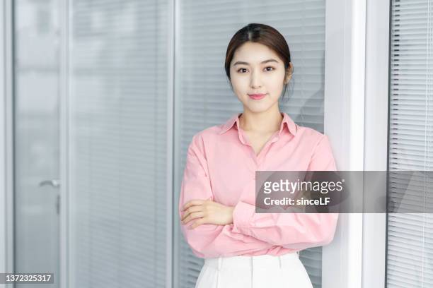 an attractive asian businessman smiles at the camera - pink collared shirt stock pictures, royalty-free photos & images