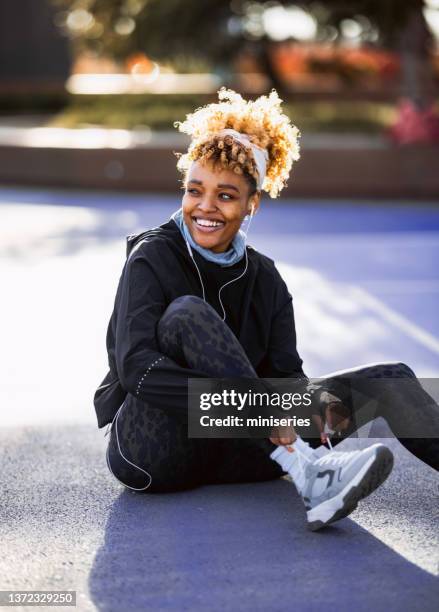 anonymous afro-american woman preparing for a workout - paarse schoen stockfoto's en -beelden