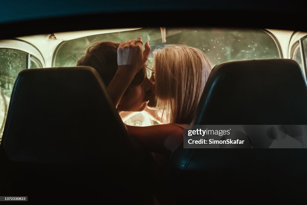 Young couple kissing each other in car during date